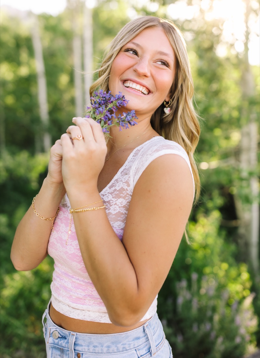 Harper smiling with purple wildflowers