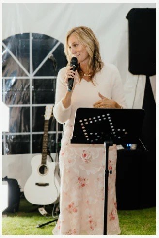Niki speaking into a microphone on stage